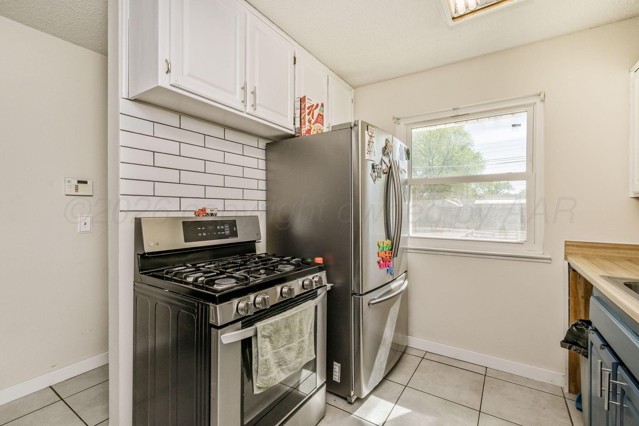 2907 South Manhattan Street Amarillo, TX 79103 - Photo 6 of 16 a kitchen with stainless steel appliances granite countertop a refrigerator and a stove