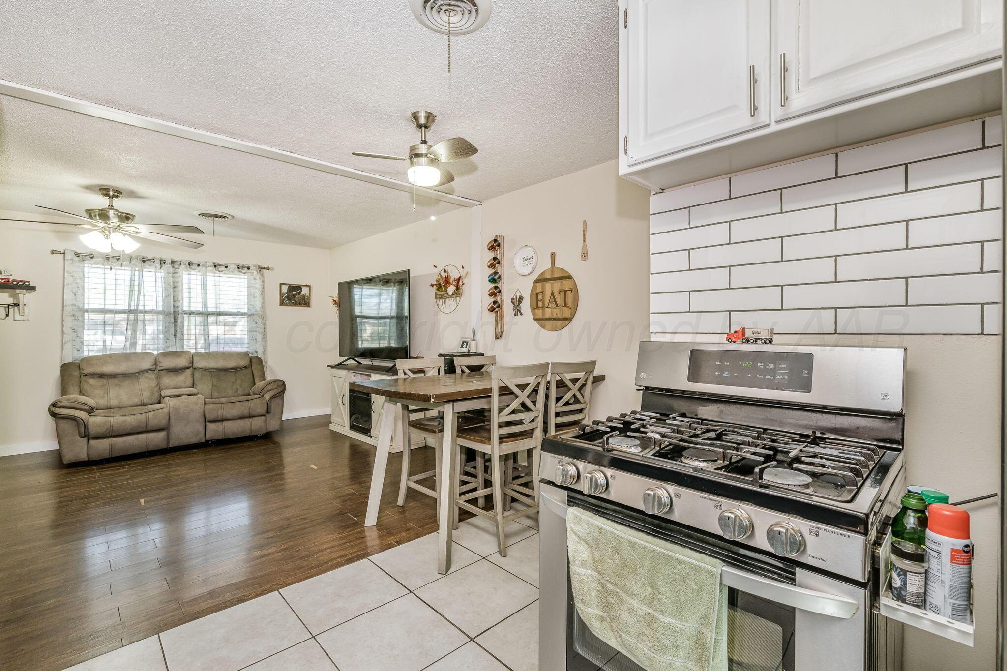 2907 South Manhattan Street Amarillo, TX 79103 - Photo 7 of 16 a kitchen with stainless steel appliances stove top oven and cabinets