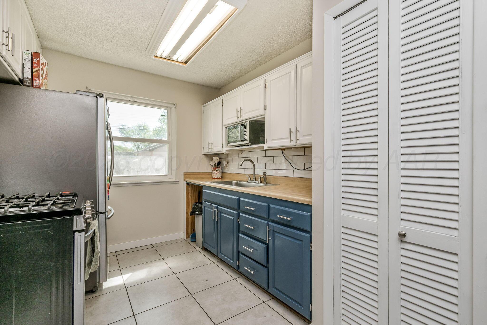2907 South Manhattan Street Amarillo, TX 79103 - Photo 8 of 16 a kitchen with stainless steel appliances a sink stove and cabinets
