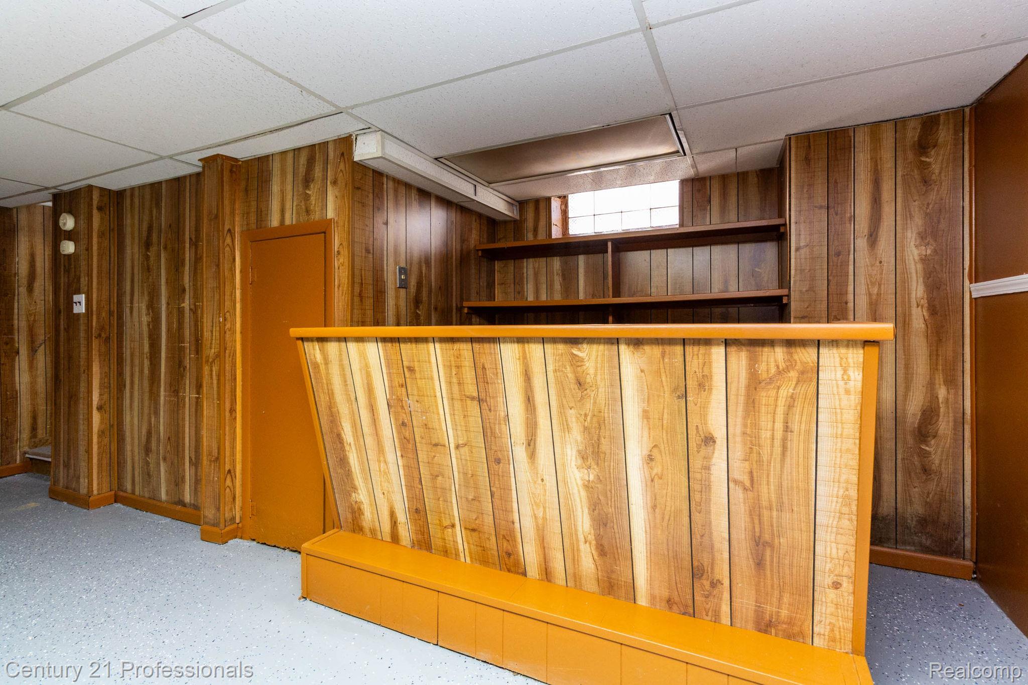18951 Edinborough Road Detroit, MI 48219 - Photo 26 of 47 Indoor dry bar with a drop ceiling, wooden walls, open shelves, and brown cabinets
