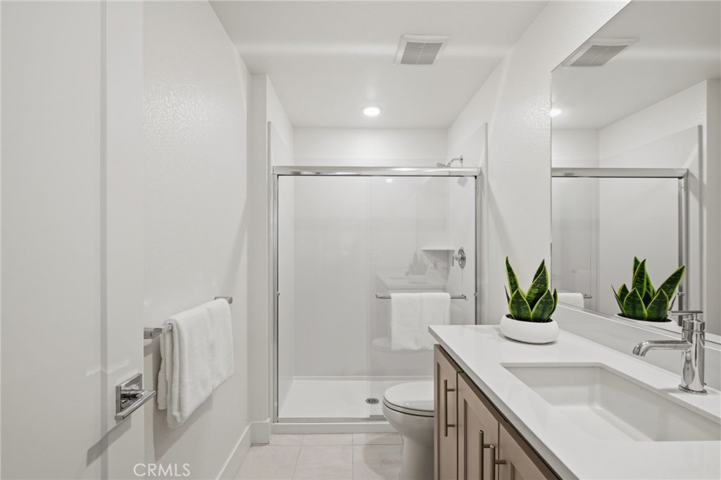 45235 Wisdom Road, Unit 1003 Fremont, CA 94538 - Photo 18 of 32 a bathroom with a granite countertop sink a toilet and shower