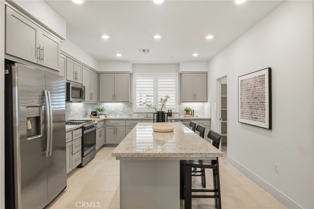 45235 Wisdom Road, Unit 1003 Fremont, CA 94538 - Photo 8 of 32 a kitchen with stainless steel appliances granite countertop a kitchen island hardwood floor sink stove and granite counter top