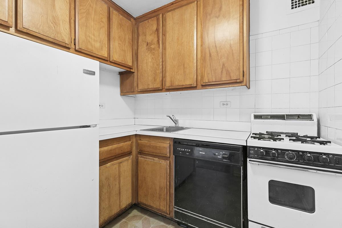 10 West 15th Street, Unit 1623 Manhattan, NY 10011 - Photo 3 of 7 a kitchen with stainless steel appliances granite countertop a sink stove and refrigerator