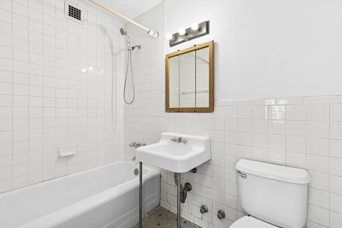 10 West 15th Street, Unit 1623 Manhattan, NY 10011 - Photo 6 of 7 a bathroom with a sink toilet and shower