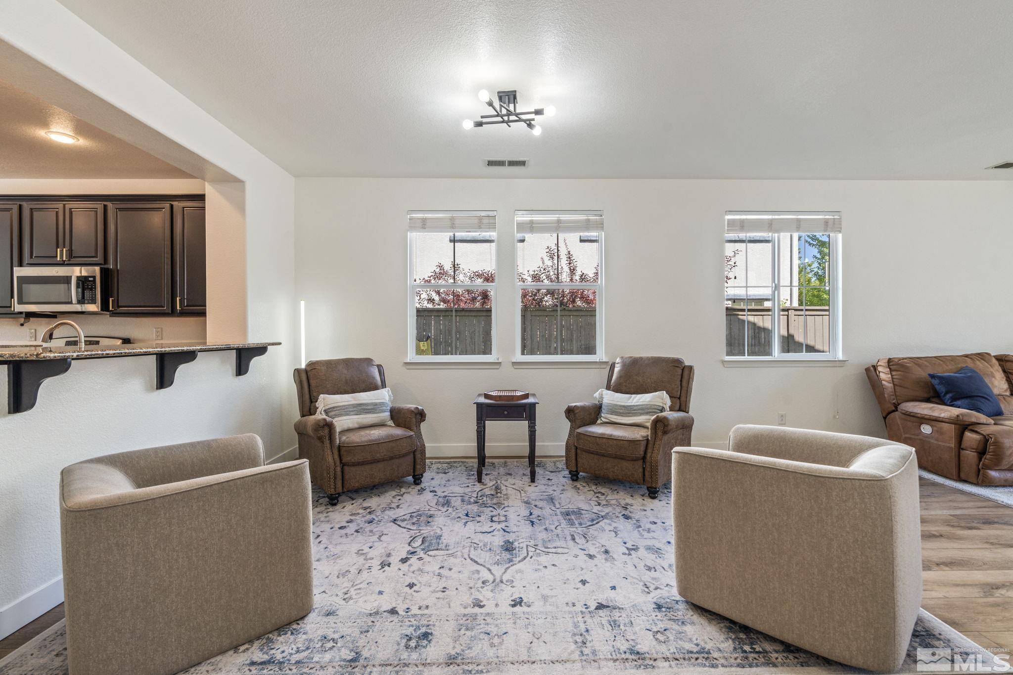 541 Needles Court Reno, NV 89521 - Photo 11 of 35 a living room with furniture a large window and a flat screen tv