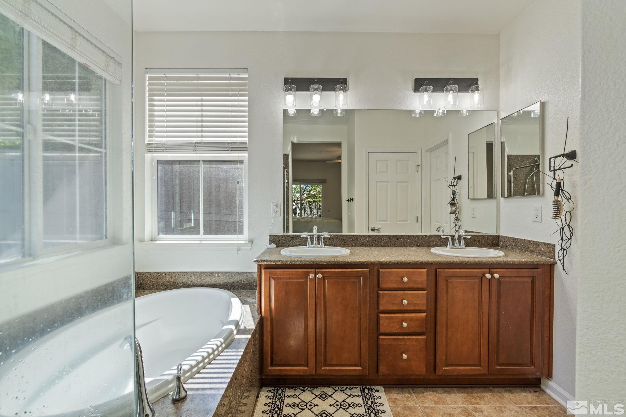 541 Needles Court Reno, NV 89521 - Photo 15 of 35 a bath room with double vanity sink and a bathtub