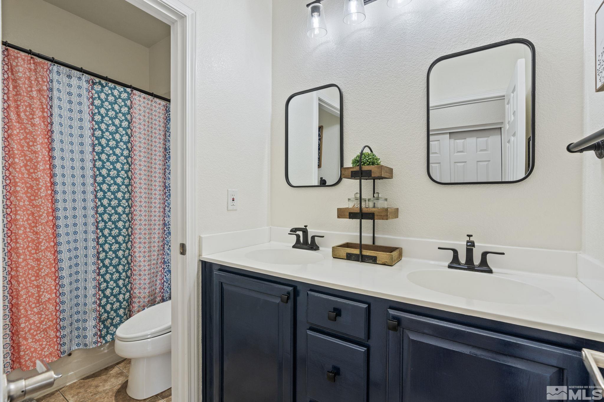 541 Needles Court Reno, NV 89521 - Photo 22 of 35 a bathroom with a double vanity sink toilet and a mirror