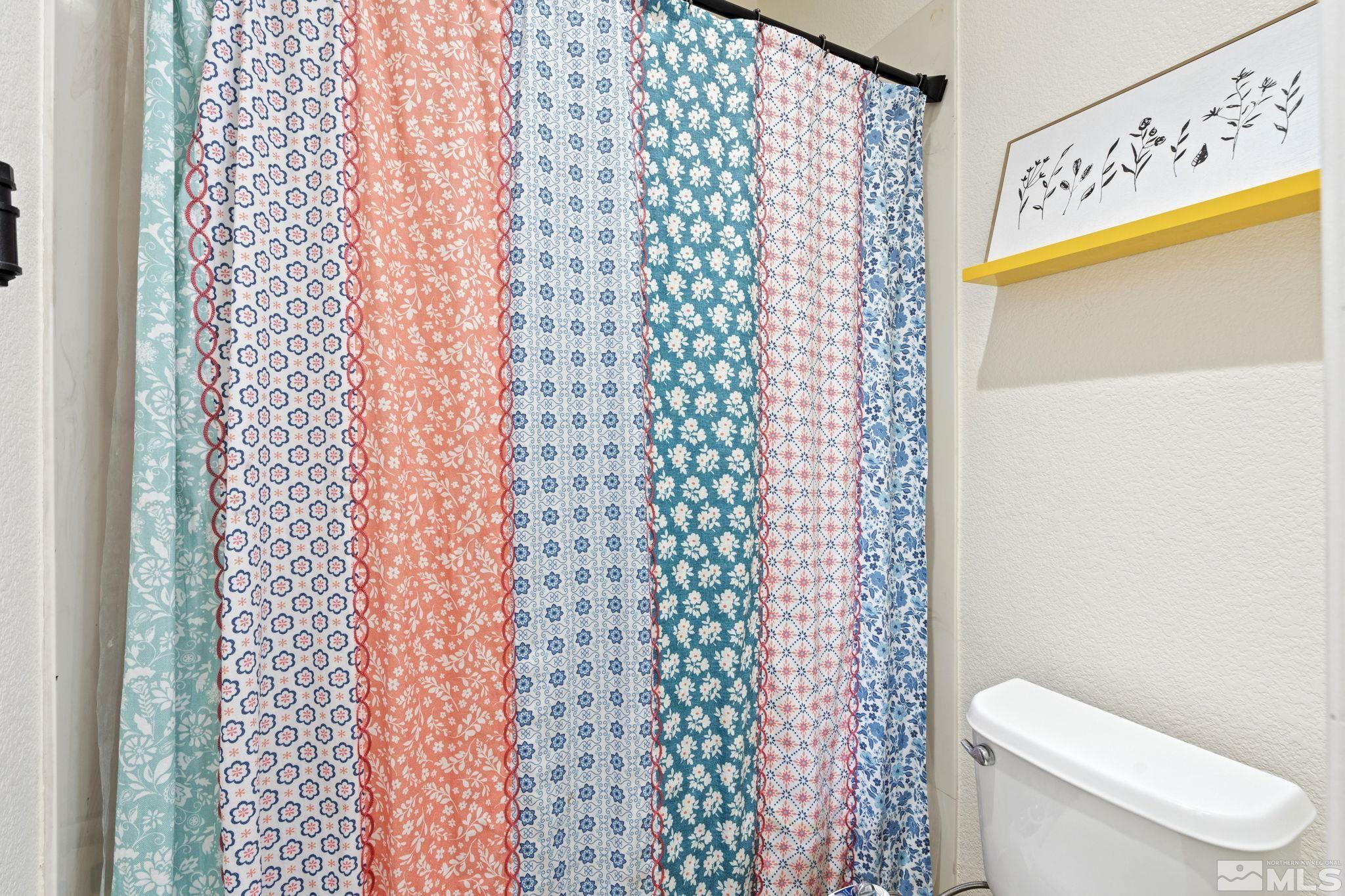 541 Needles Court Reno, NV 89521 - Photo 23 of 35 a bathroom with a toilet and a shower curtain