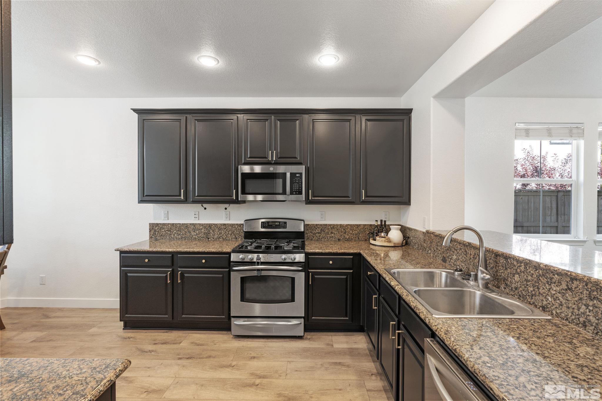 541 Needles Court Reno, NV 89521 - Photo 10 of 35 a kitchen with stainless steel appliances granite countertop a sink stove and microwave