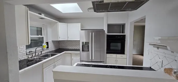 a kitchen with stainless steel appliances a refrigerator and a stove top oven