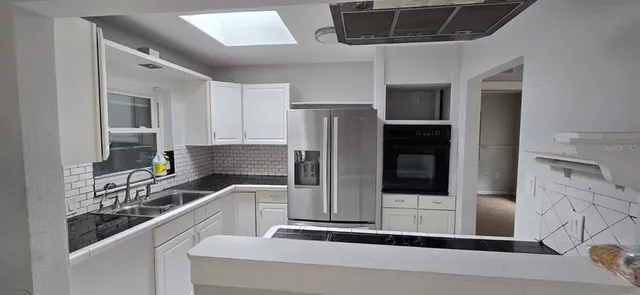 a kitchen with stainless steel appliances a refrigerator and a stove top oven