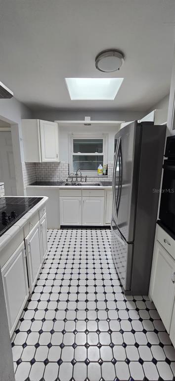 480 Sharon Circle Port Charlotte, FL 33952 - Photo 6 of 16 a kitchen with a sink a refrigerator and cabinets