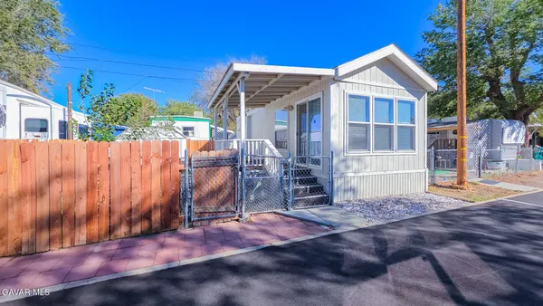 a view of a house with wooden fence next to a yard
