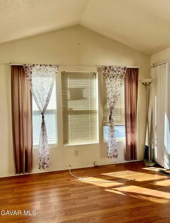 a view of a livingroom with wooden floor and a window