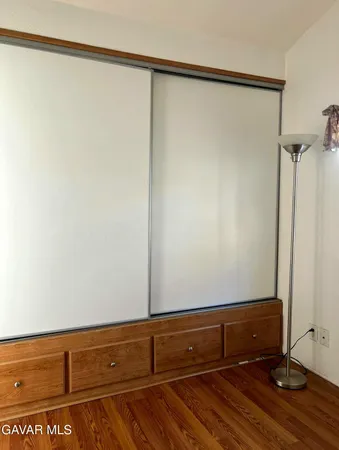a view of room with hardwood floor and cabinet