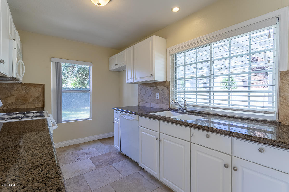 2276 Rohner Court Simi Valley, CA 93063 - Photo 9 of 20 a kitchen with granite countertop a sink white cabinets and a window
