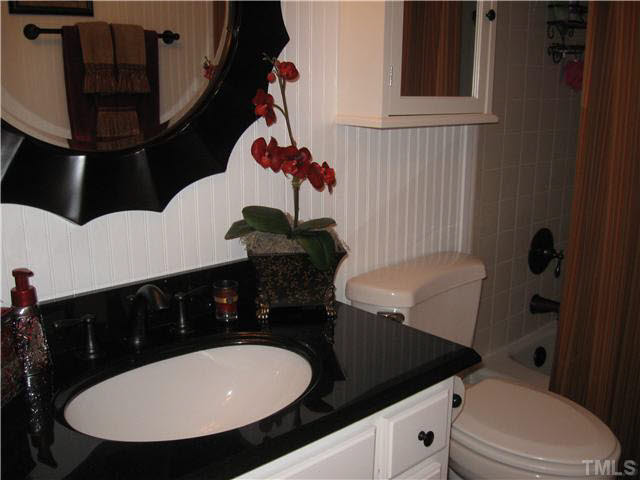 8809 Wellsley Way Raleigh, NC 27613 - Photo 14 of 25 UPDATED hall bath... Bead board, granite....tiled bath/shower...and the floor is your surprise when you come take a look. (could not get good angle to show here!)