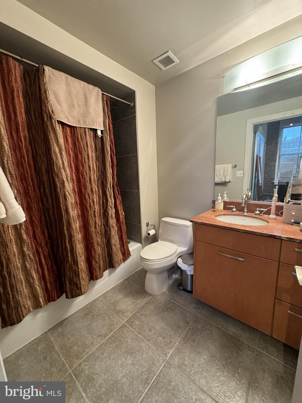 916 G St. Northwest, Unit 805 Washington, DC 20001 - Photo 5 of 19 a bathroom with a sink a toilet a mirror and shower