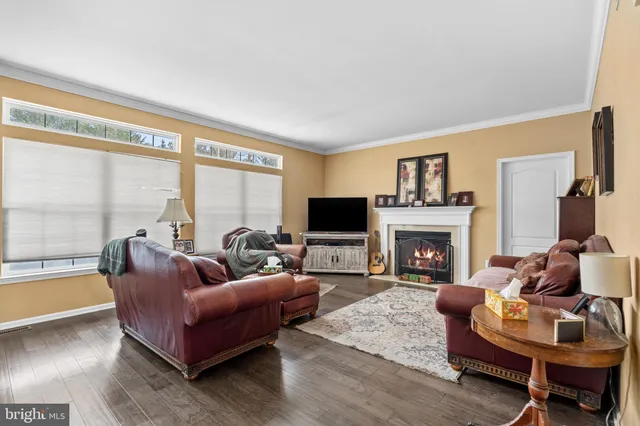 a living room with furniture a large window and a fireplace