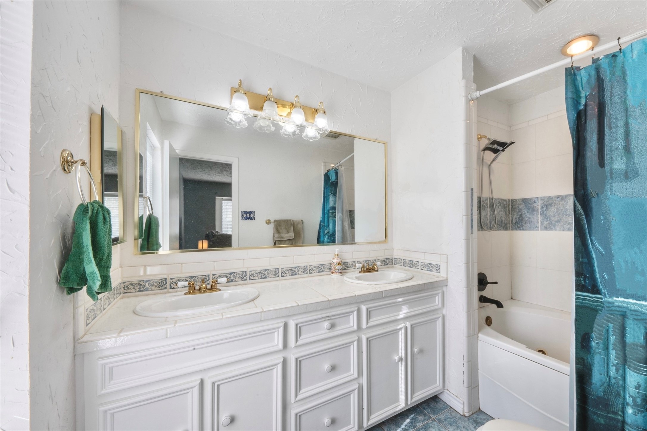 17314 Edenbridge Court Spring, TX 77379 - Photo 19 of 33 a bathroom with a sink a mirror and a bathtub next to a window