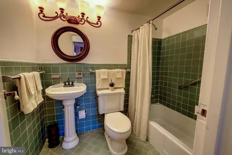 a bathroom with a sink mirror toilet and bathtub