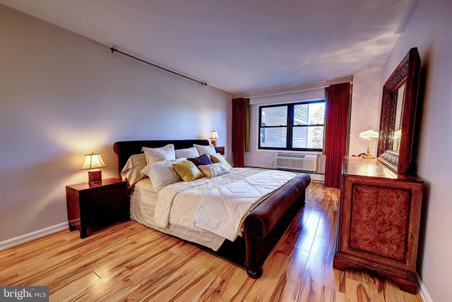 a spacious bedroom with a bed and wooden floor