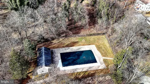 a view of a swimming pool with lawn chairs under an umbrella