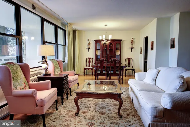 a living room with furniture fireplace and a large window