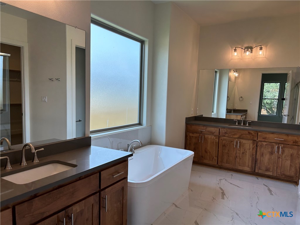 5903 Whippoorwill Road Temple, TX 76502 - Photo 14 of 27 a bathroom with a granite countertop sink a mirror and a bathtub