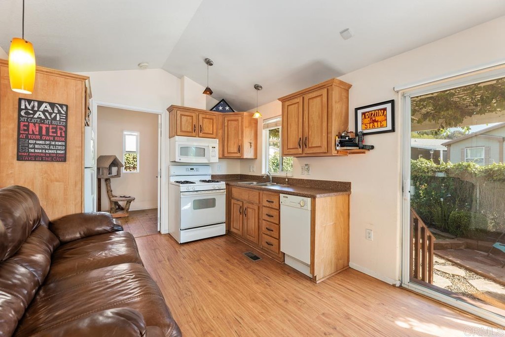 3909 Reche Road, Unit 195 Fallbrook, CA 92028 - Photo 5 of 25 a kitchen with stainless steel appliances granite countertop a stove a sink dishwasher and a refrigerator with wooden floor