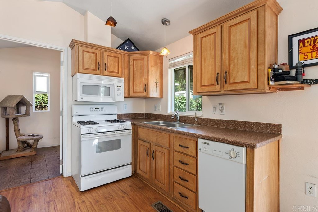 3909 Reche Road, Unit 195 Fallbrook, CA 92028 - Photo 6 of 25 a kitchen with stainless steel appliances granite countertop a sink a stove cabinets and wooden floor