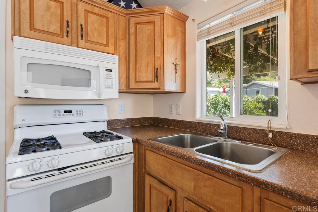 3909 Reche Road, Unit 195 Fallbrook, CA 92028 - Photo 7 of 25 a kitchen with granite countertop white cabinets sink and appliances