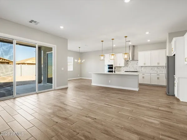 a view of kitchen with kitchen island a sink wooden floor and a refrigerator