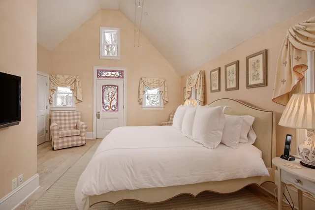 a bedroom with a bed and a flat tv screen on dresser