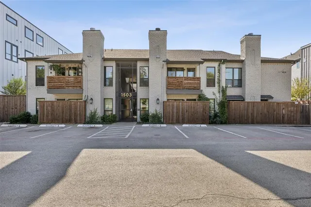 a front view of a house with yard and parking