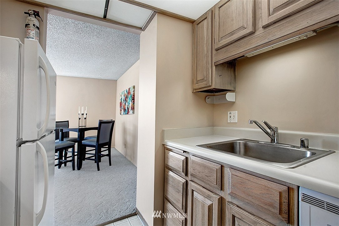 2201 3rd Avenue, Unit 1001 Seattle, WA 98121 - Photo 9 of 20 a kitchen with a sink cabinets and dining table