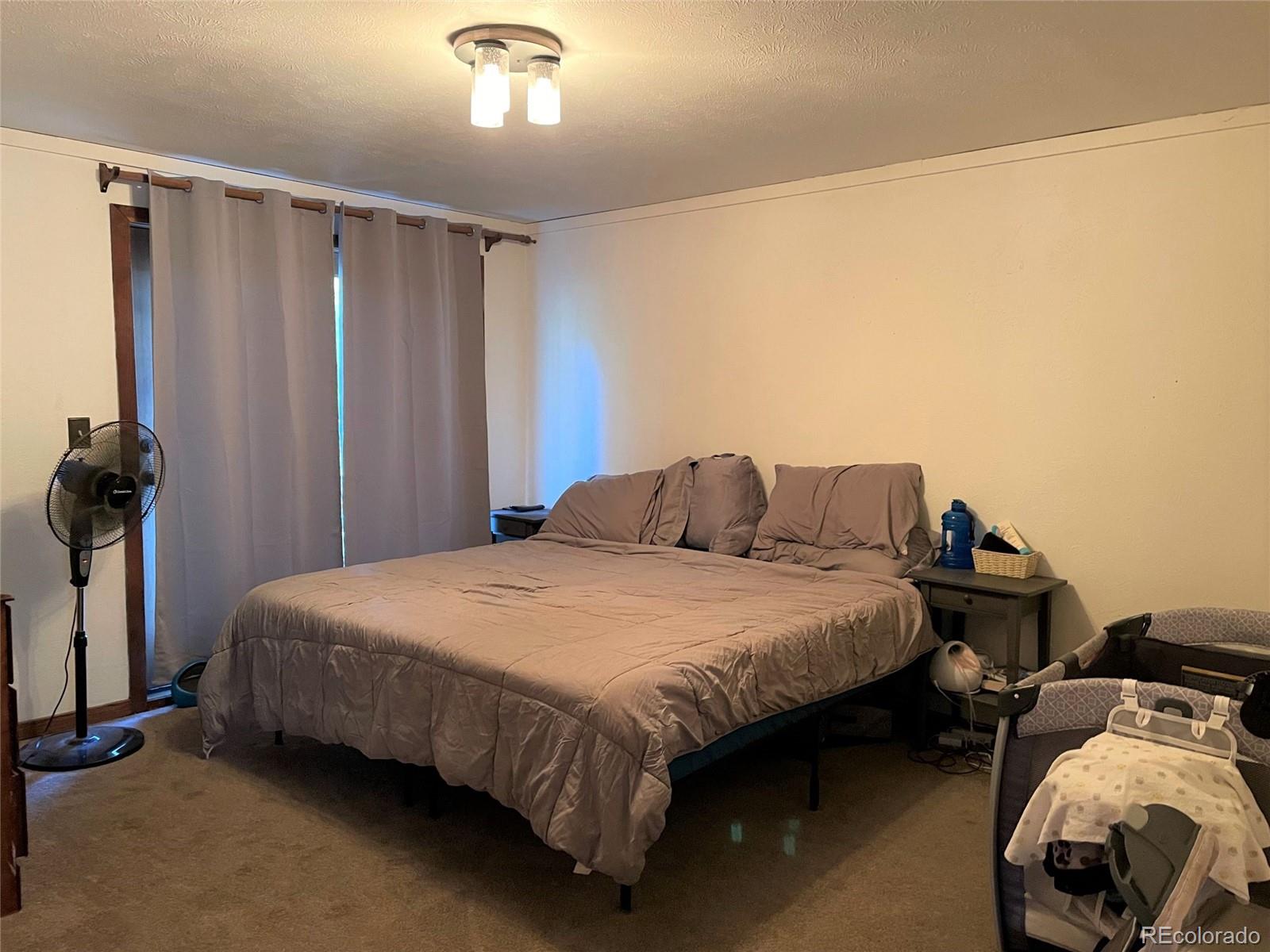 69 County Road 114 Bailey, CO 80421 - Photo 11 of 34 a bedroom with bed and a chandelier