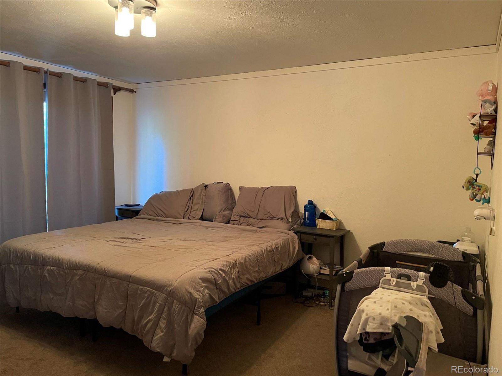 69 County Road 114 Bailey, CO 80421 - Photo 12 of 34 a bedroom with a bed and a chandelier