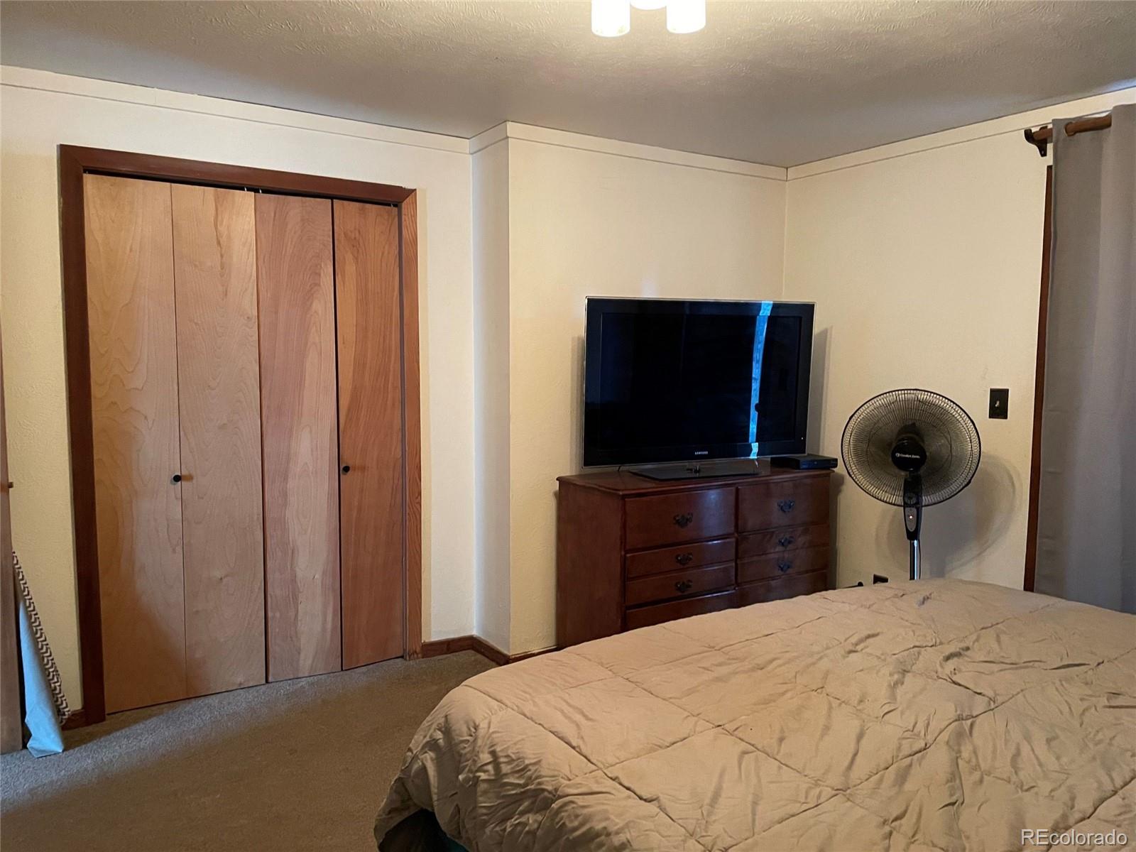 69 County Road 114 Bailey, CO 80421 - Photo 13 of 34 a bedroom with a bed and a flat screen tv