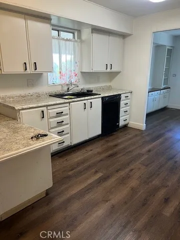a kitchen with granite countertop a sink and cabinets