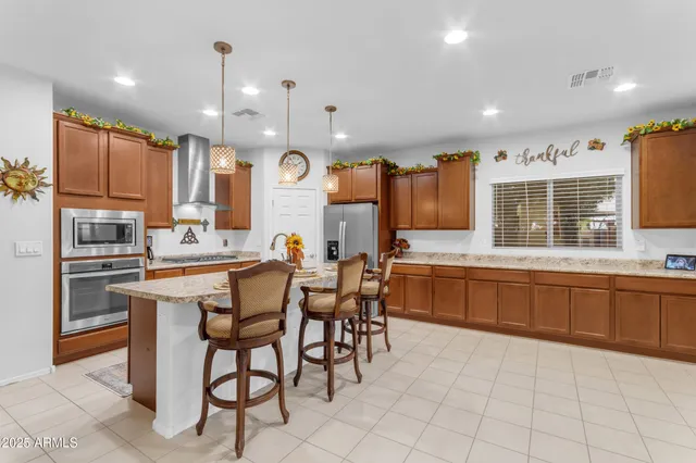 a kitchen with stainless steel appliances granite countertop a stove a sink and a refrigerator