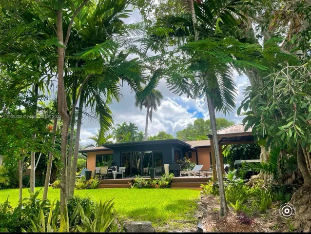 a front view of a house with garden and swimming pool