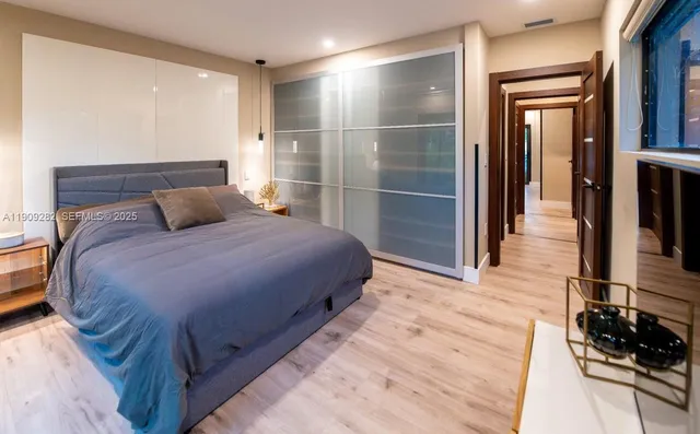 a bedroom with a bed and wooden floor