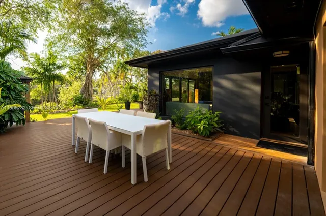 a view of a patio with table and chairs with wooden floor and fence