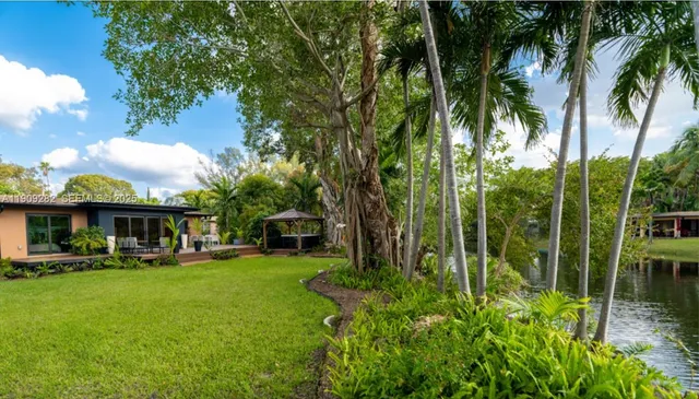 a view of a house with a yard patio and swimming pool