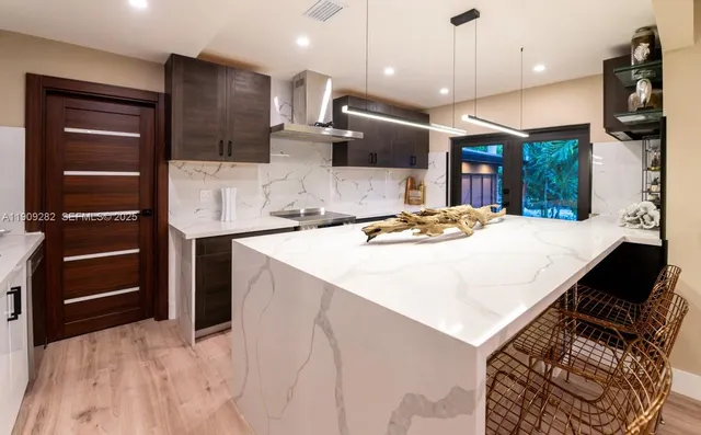 a kitchen with stainless steel appliances kitchen island a refrigerator sink and stove