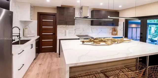 a kitchen with stainless steel appliances kitchen island granite countertop a sink and cabinets