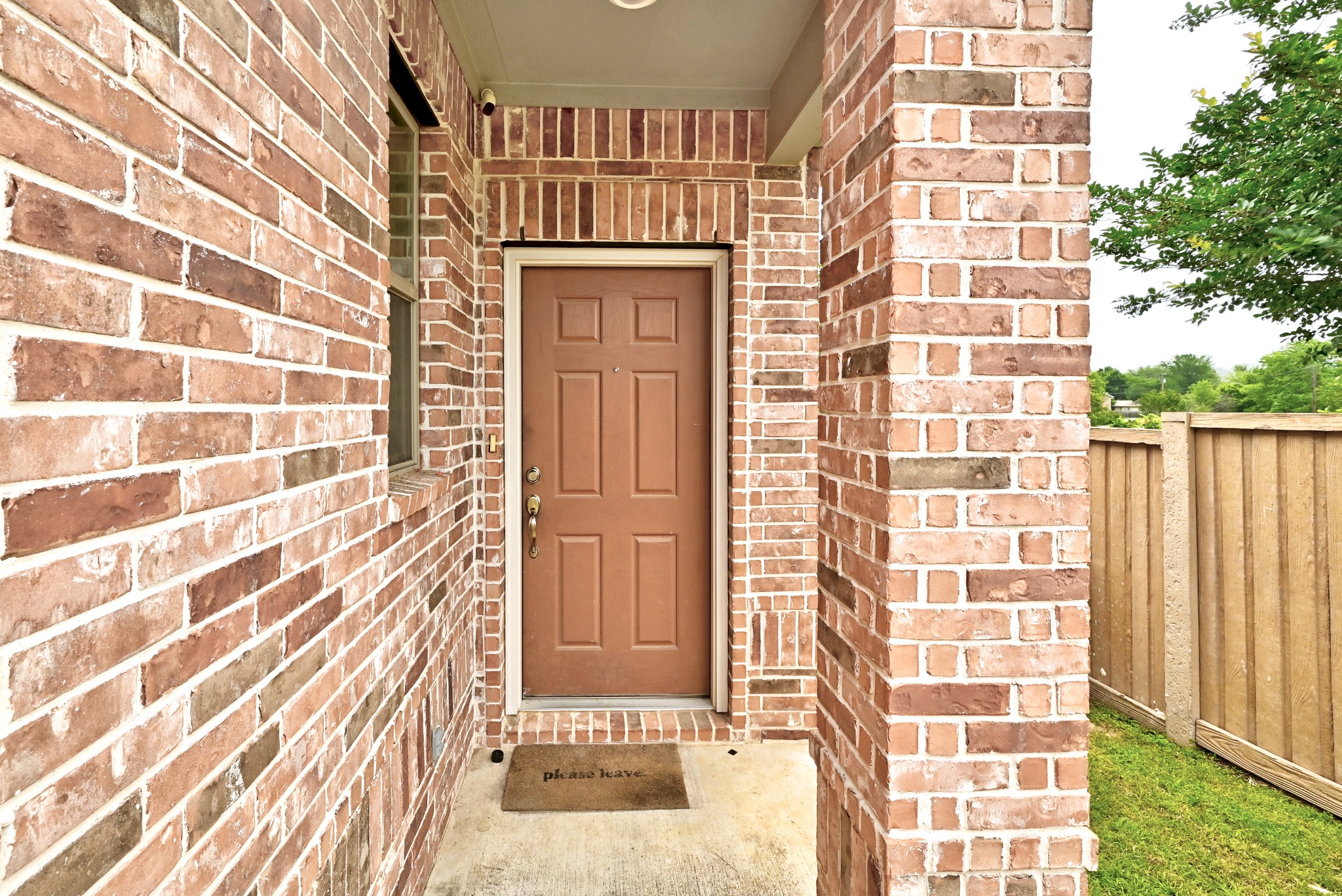1621 Dragonfly Loop Bastrop, TX 78602 - Photo 5 of 27 Brick exterior with a paneled front door, sidelight window, and concrete entry pad