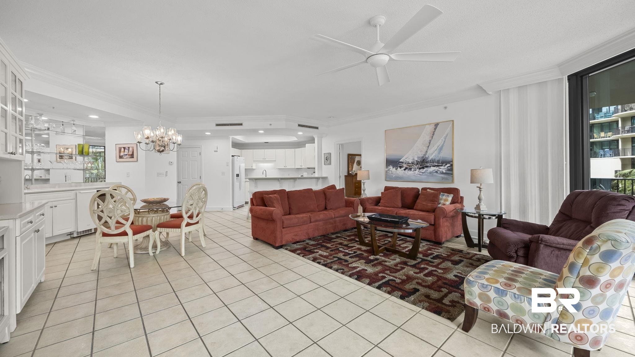 27580 Canal Road, Unit 1213 Orange Beach, AL 36561 - Photo 2 of 27 Open-concept living area featuring tile flooring, a ceiling fan, and a built-in wet bar with glass-front cabinetry