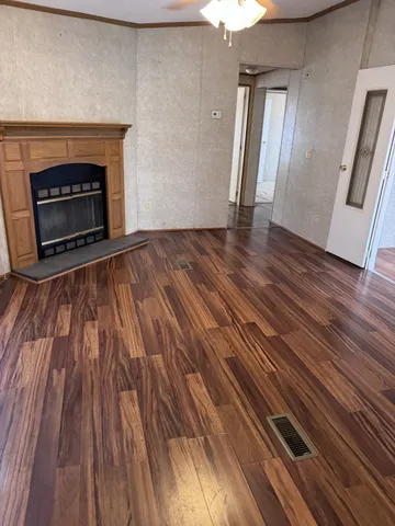 an empty room with wooden floor and fireplace